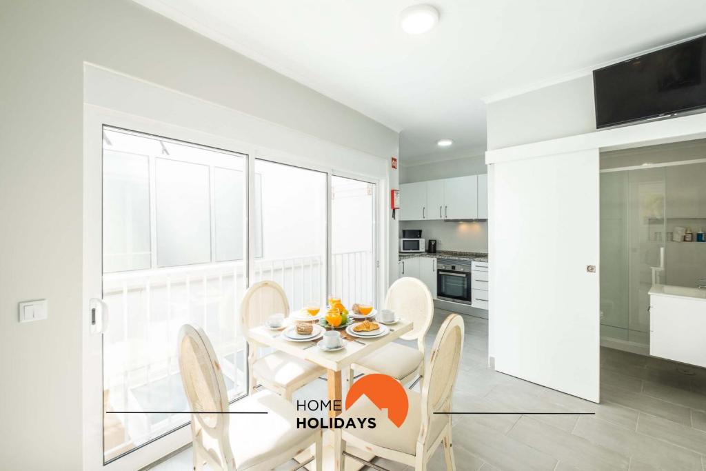 une cuisine avec une table et des chaises dans une pièce dans l'établissement #097 Casa Antonieta 2 by Home Holidays, à Albufeira