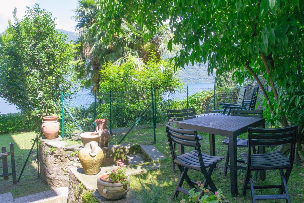 a table and chairs in a backyard with a view of the water at Casa Liberty - WelcHome in Cannobio