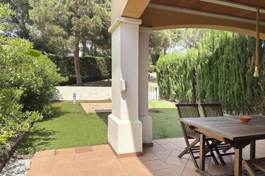 a porch with a wooden table and chairs on a patio at LETS HOLIDAYS Luxury house in Cala Llevado in Tossa de Mar