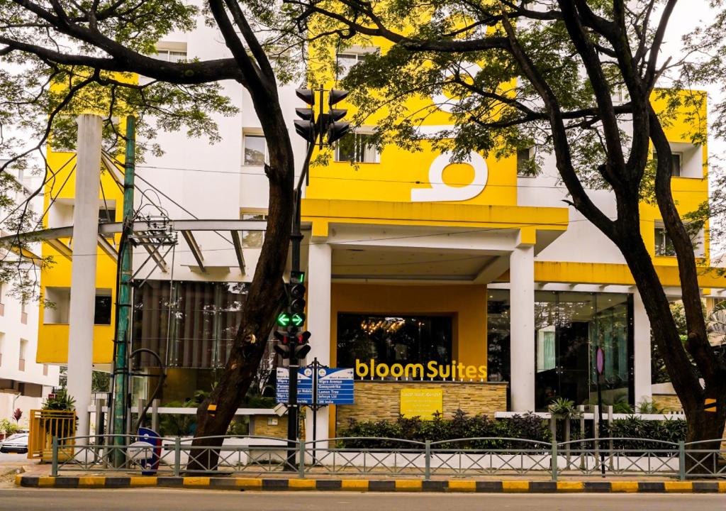 a yellow building with a brown survey sign on it at BloomSuites I Electronics City in Bengaluru