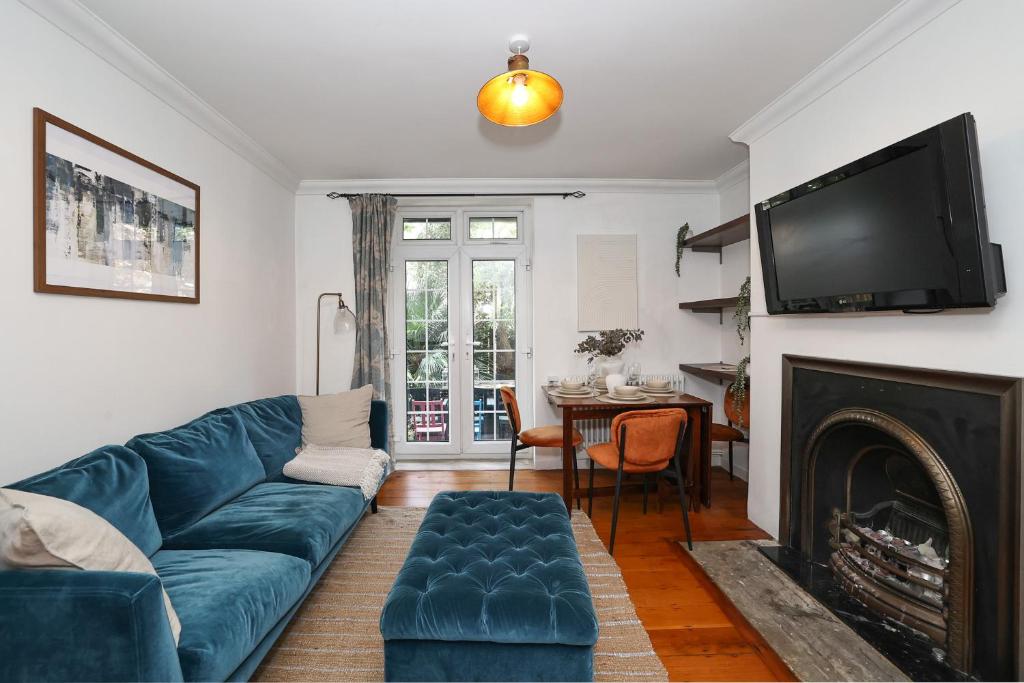 a living room with a blue couch and a fireplace at Bright & modern Islington 2BD apt for 6 in London