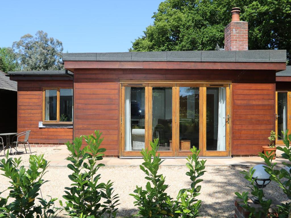 a small house with glass doors and a chimney at Badgers Sett in Fareham