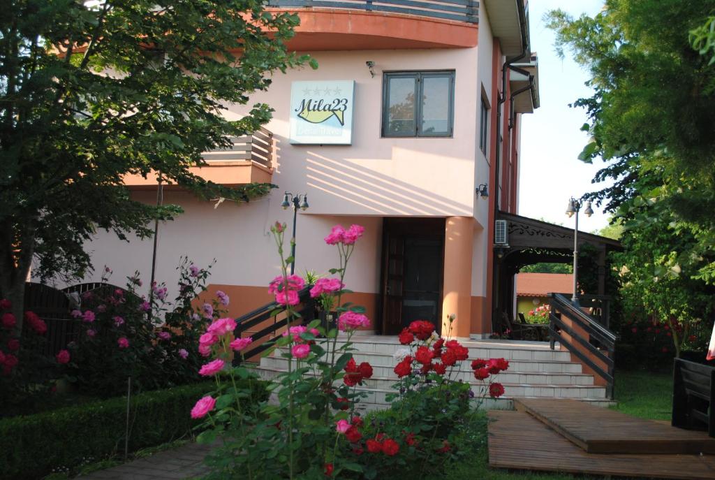uma casa com flores cor-de-rosa em frente em Vila Delta Travel - Mila 23 em Mila Douazeci si Trei