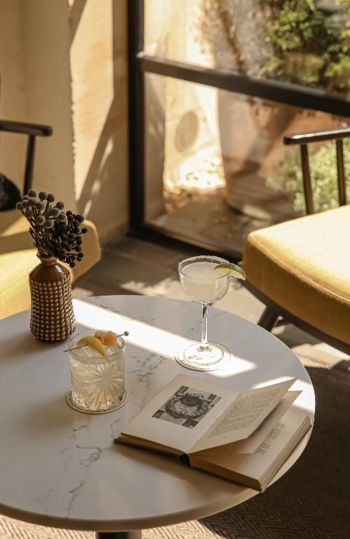 un tavolo con un libro e un bicchiere di vino sopra di The Yard in Bath Hotel a Bath