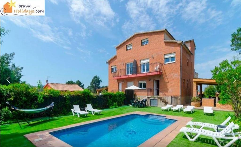 a home with a swimming pool and a house at Bravaholidays-601-Lloret Park 1 in Vidreres