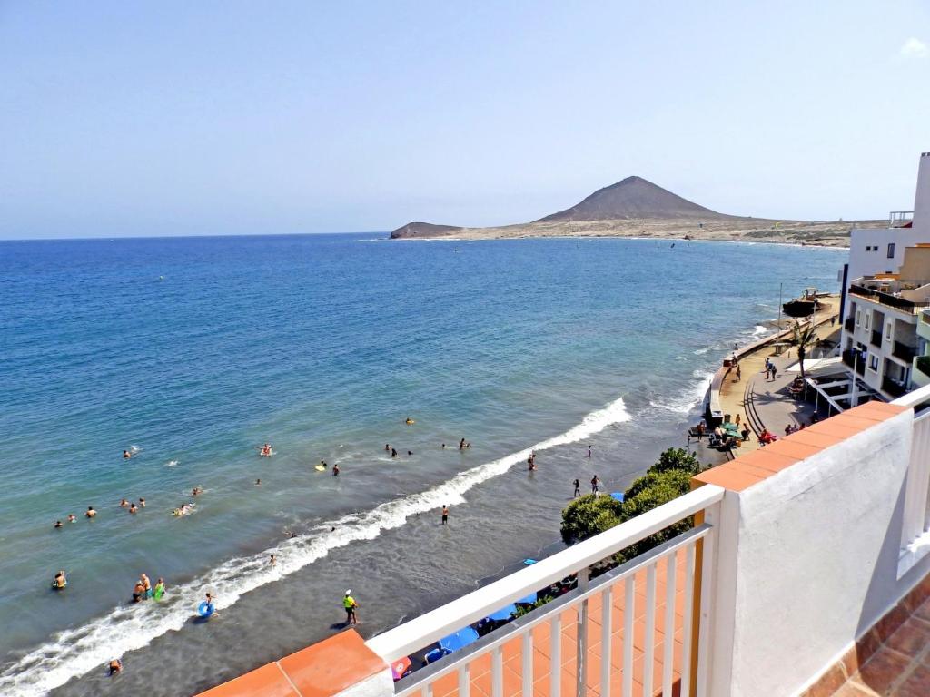 Blick auf den Strand mit Menschen im Wasser in der Unterkunft Apartamentos Medano - Atico Playa in El Médano