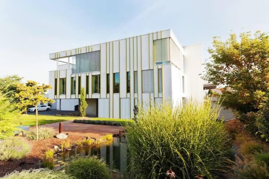 een kantoorgebouw met een vijver ervoor bij Luxury Villa EMG Frankfurt Heidelberg - Bensheim in Bensheim