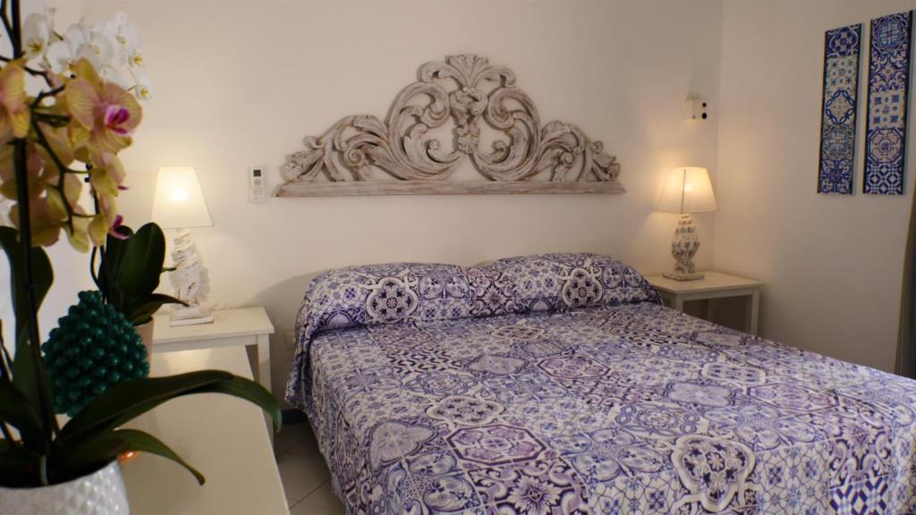 パナレーアにあるLa Piazza Luxury Hotel & Spaのベッドルーム1室(ベッド1台、ランプ付きテーブル2台付)