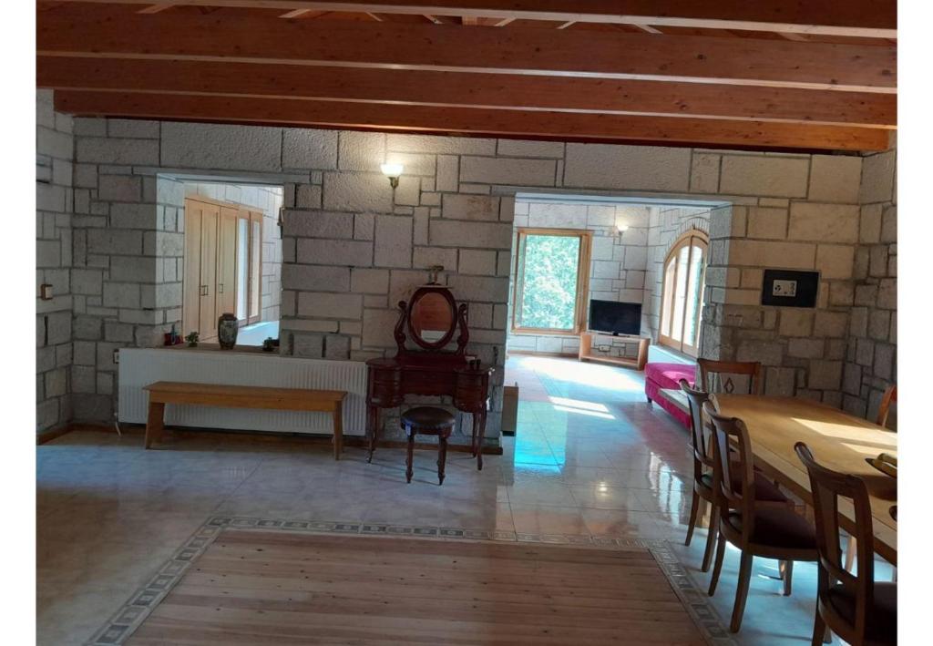 a living room with a stone wall and a table at Tsarouxi village 1 in Karditsa