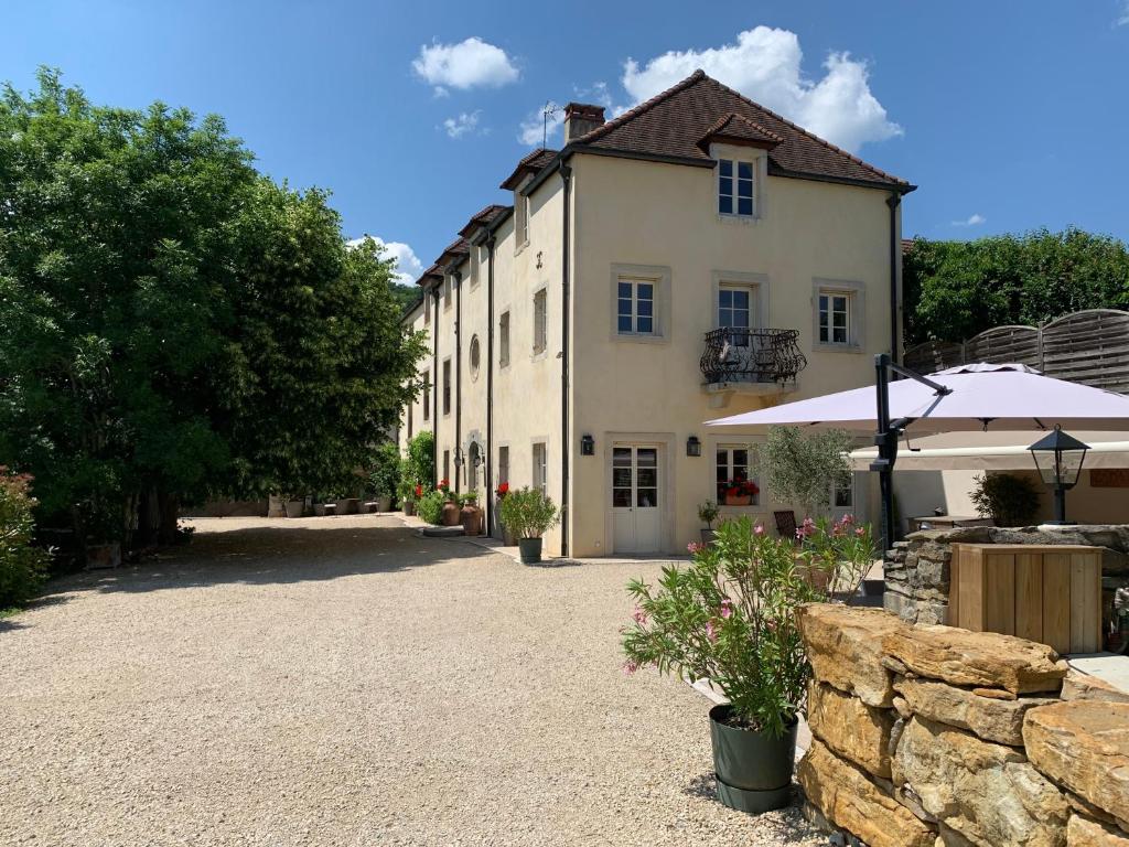 a large white building with a stone wall at Villa Emma in Mavilly-Mandelot