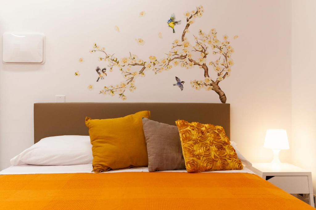 ein Schlafzimmer mit einem Bett mit einem Baum an der Wand in der Unterkunft Casa Vacanza Nibbio 26 in Sperlonga