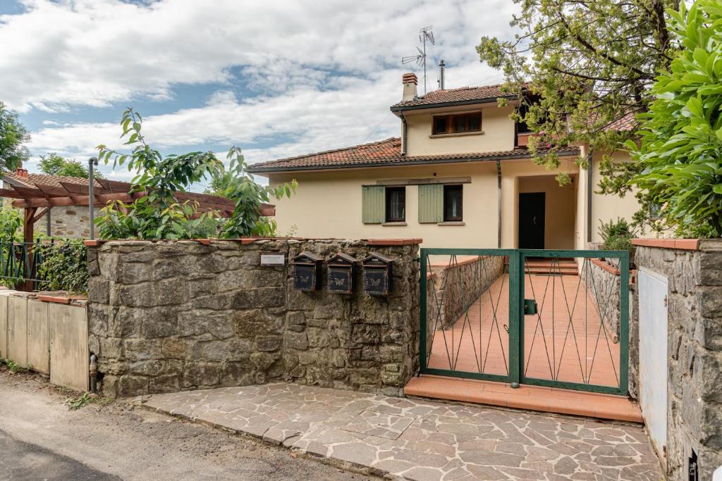 een huis met een poort en een stenen muur bij Bio - Vaglia in Vaglia