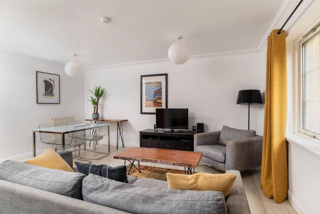 ein Wohnzimmer mit einem Sofa und einem Tisch in der Unterkunft 2 Alexandra Court in St Andrews