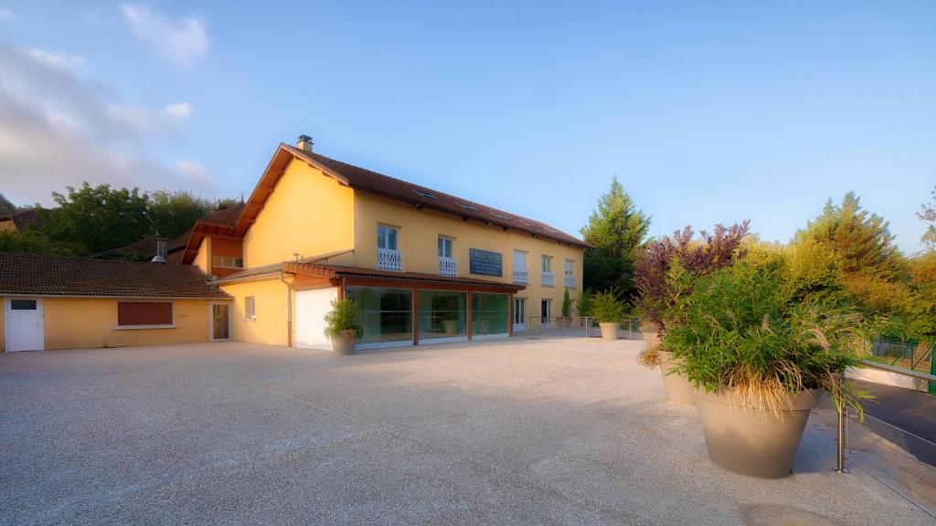 a large yellow building with a large driveway at Domaine chloé du lac in Montferrat