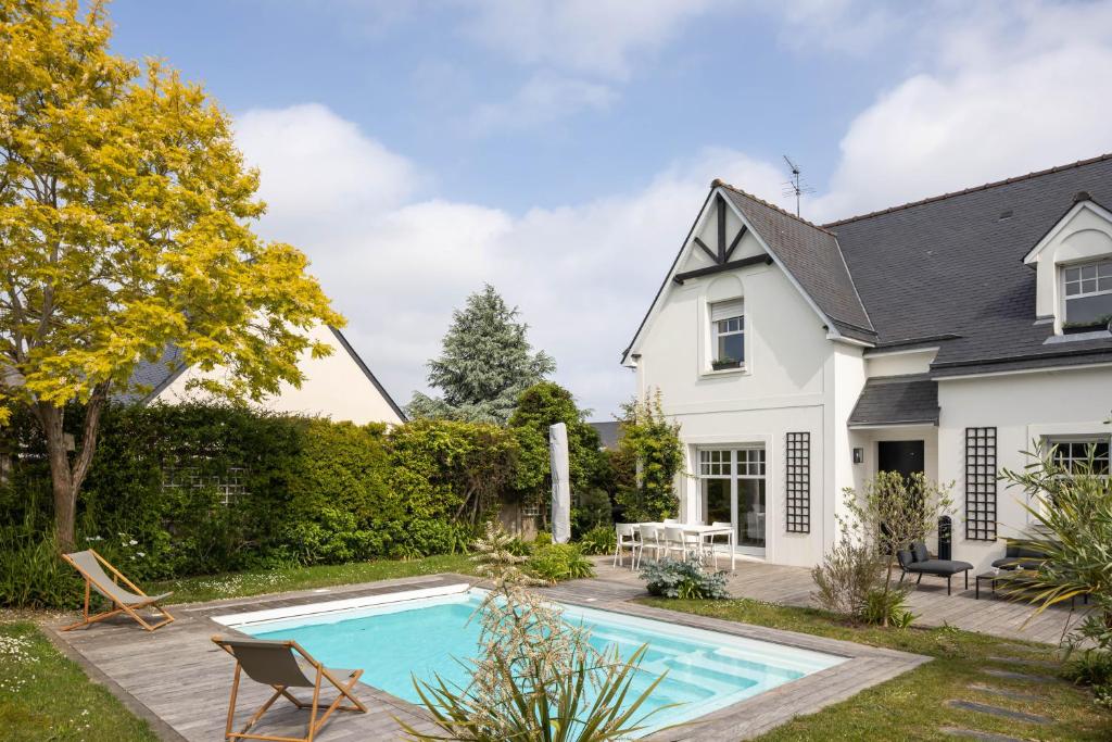 uma casa com piscina no quintal em La Villa des Rochettes - Charmante maison avec piscine et jardin em Dinard