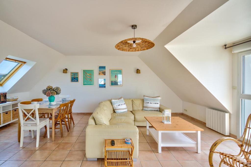 a living room with a couch and a table at Ty Jamamo - Vue mer à 500m de la plage in Saint-Nic