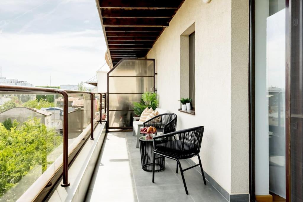 a balcony with two chairs and a table on it at Vivando - Bright 1BR - Amazing Terrace + Parking in Bucharest