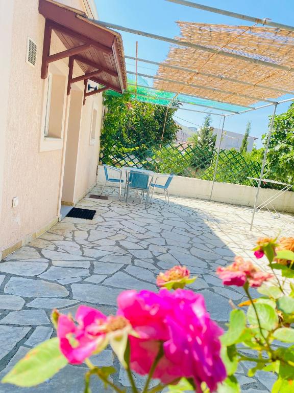a patio with chairs and pink flowers in front of a building at Villa Privata a Cefalonia in Fársa