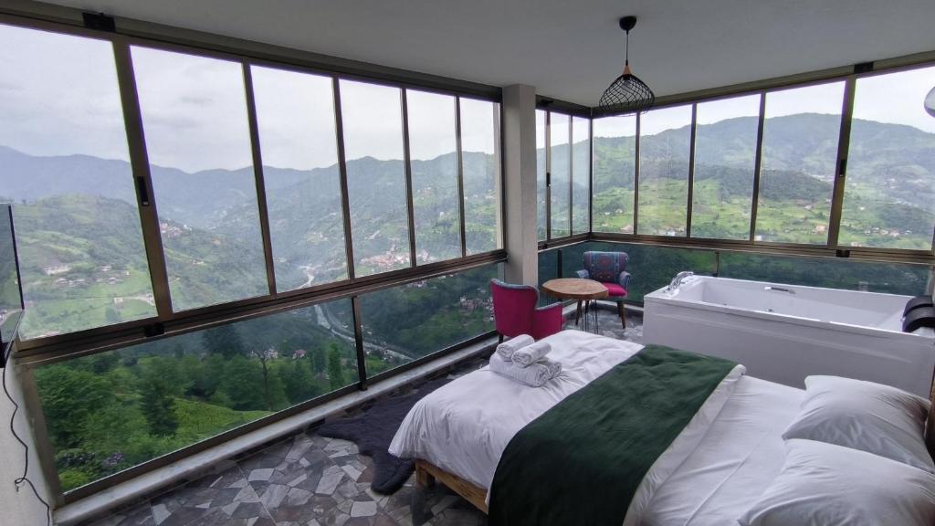een slaapkamer met een bed en uitzicht op de bergen bij Burahan Suit Hotel in Çamlıhemşin