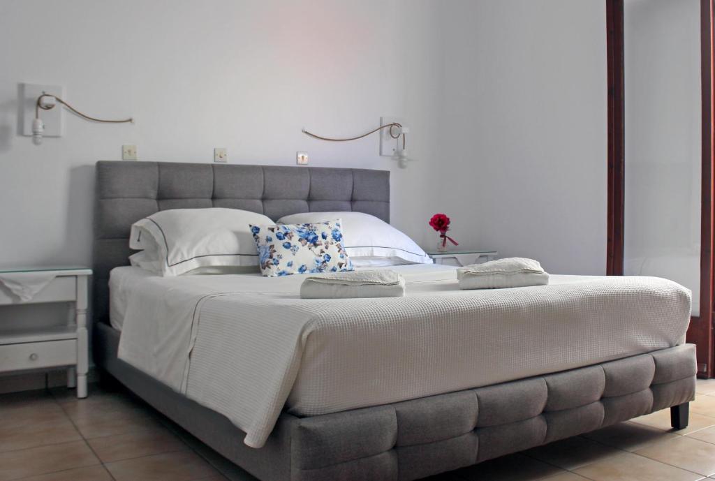 a bedroom with a large bed with white sheets and pillows at KIMASIS by Maria in Samos