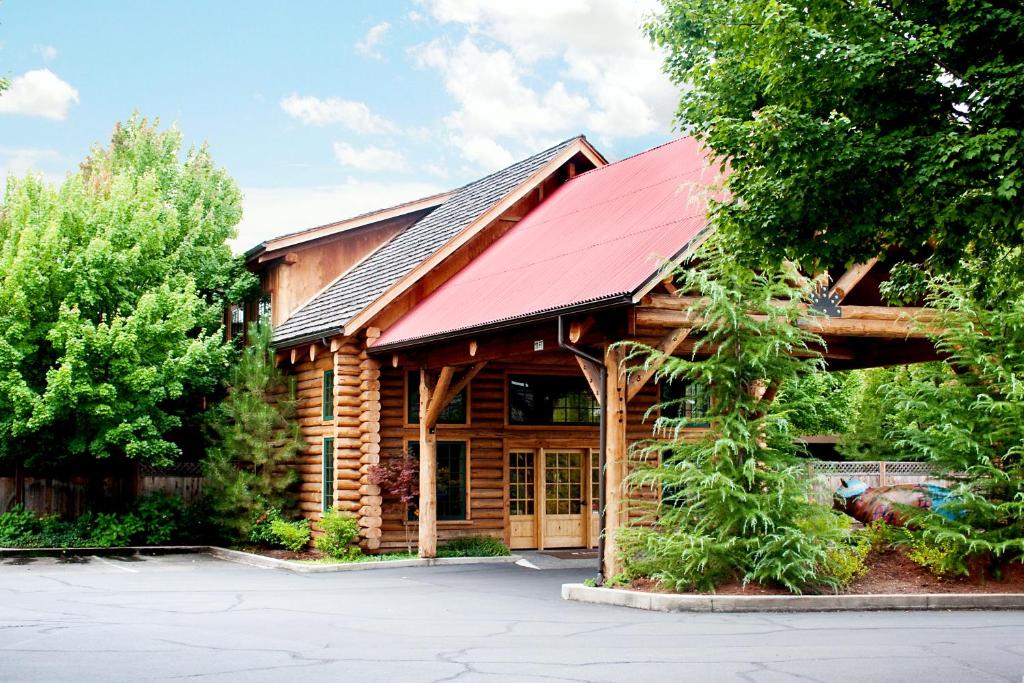 a log cabin with a red roof at The Lodge at Riverside in Grants Pass