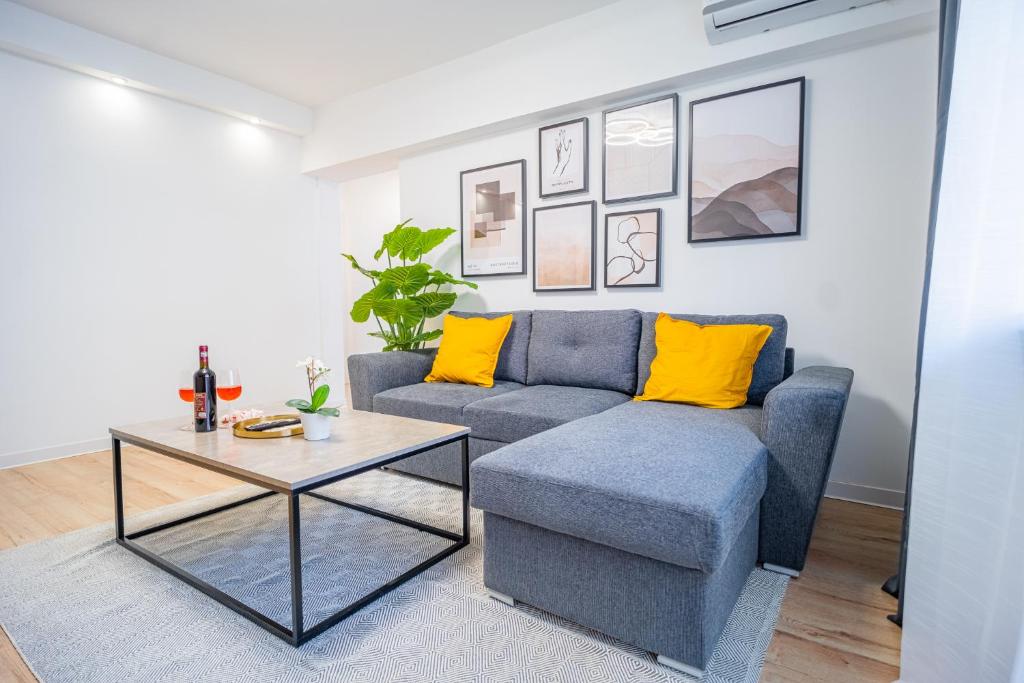 een woonkamer met een blauwe bank en een tafel bij Refreshingly Chic: Newly Renovated 2BR Apartment in Boekarest