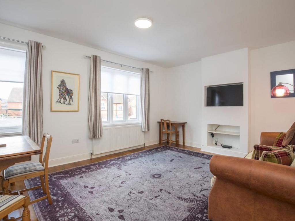 a living room with a couch and a table at Pass the Keys Chic 1 Bed Flat in Quaint Sunninghill Village in Ascot