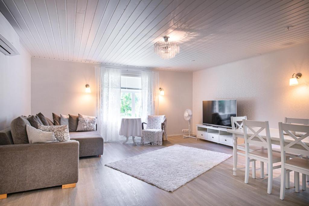 a living room with a couch and a tv and a table at Inhan Kartano in Ähtäri