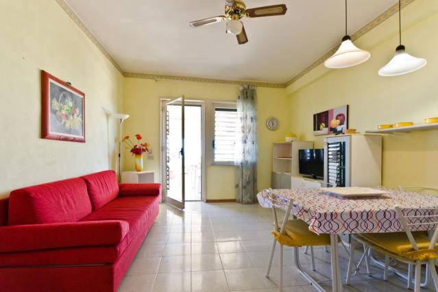 een woonkamer met een rode bank en een tafel bij Holiday House Naxos in Giardini Naxos