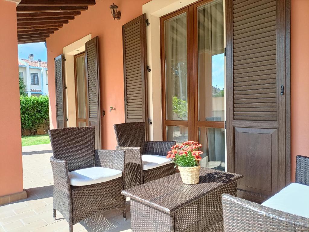 a patio with wicker chairs and a table with flowers on it at Casa Emilia - Appartamento per vacanze - Foligno in Foligno