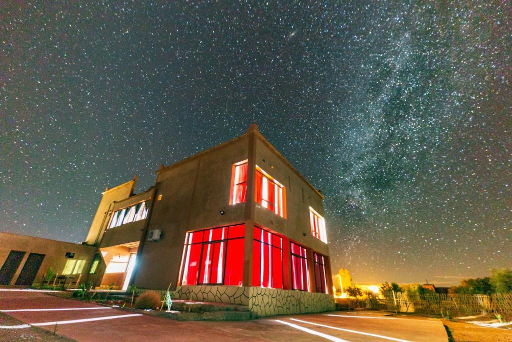 Un edificio con porte rosse sotto un cielo stellato di Palais Ksar Lamane a Aït Ben Haddou