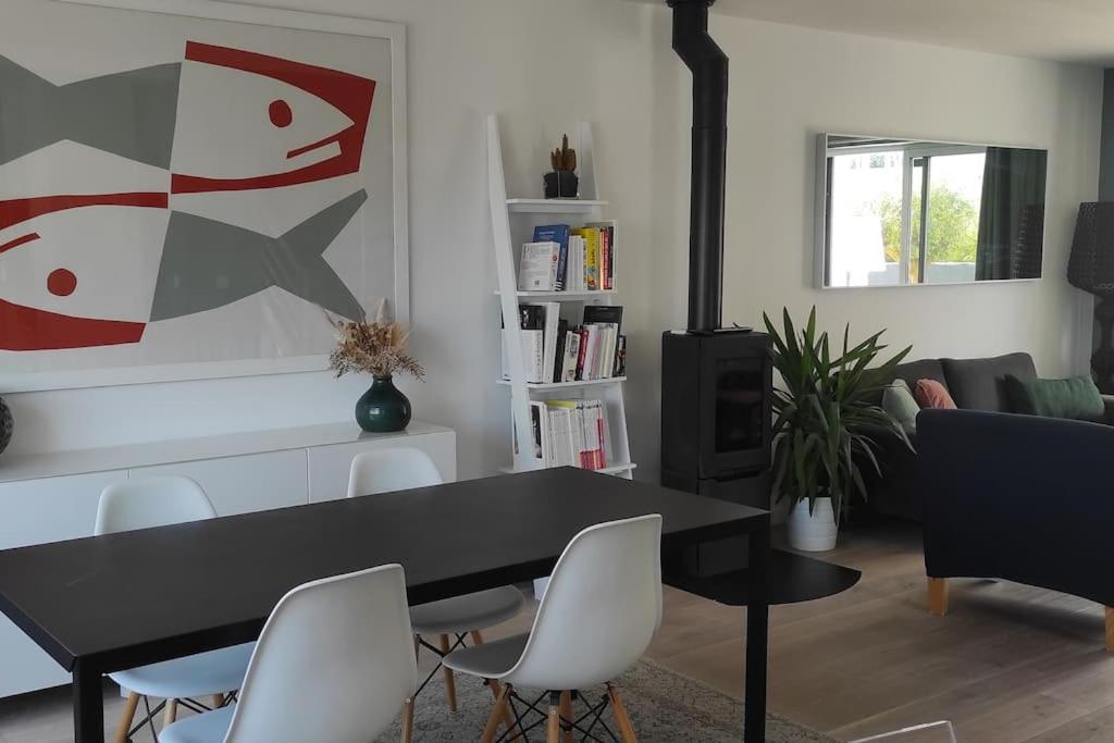 une salle à manger avec une table noire et des chaises blanches dans l'établissement Superbe maison familiale à 50 m de la plage, à Concarneau