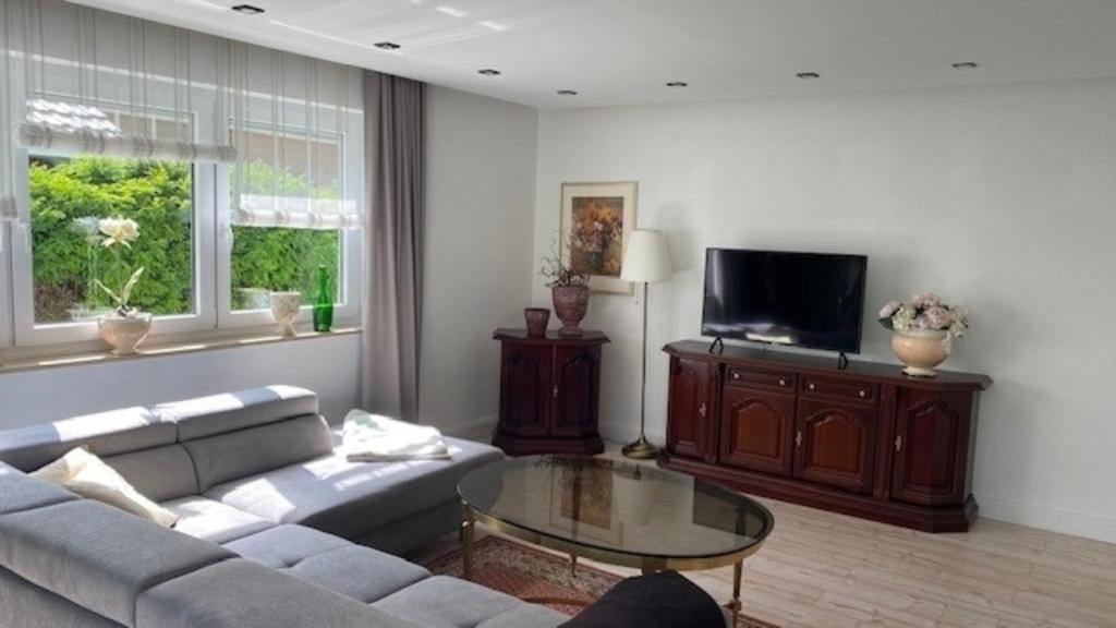 a living room with a couch and a tv at Ferienwohnung Lilienthal in Lilienthal