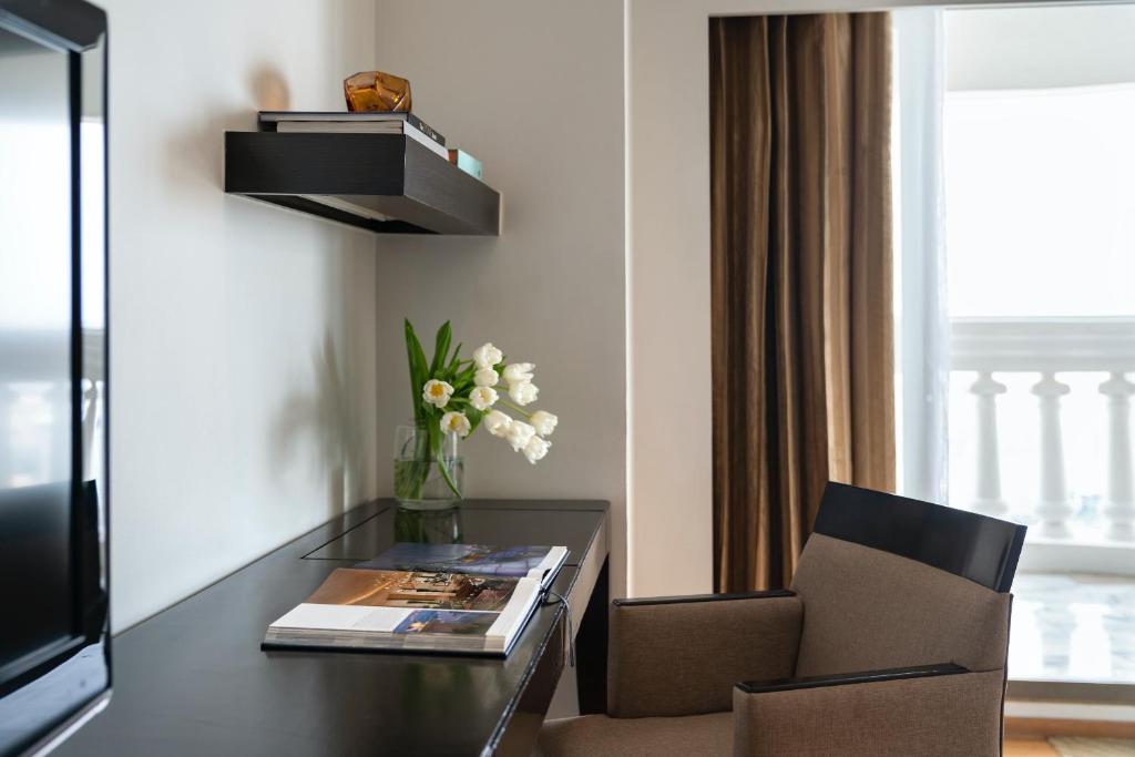 a living room with a table and a chair and a television at lebua at State Tower in Bangkok