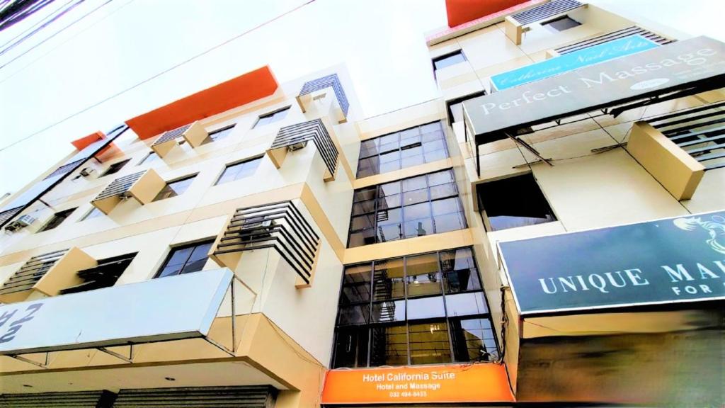 a tall building with a sign in front of it at Hotel California Suite in Sudtungan