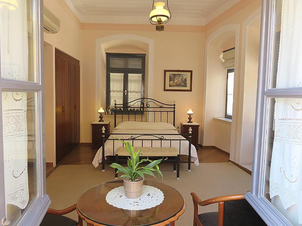 a bedroom with a bed and a table and chairs at Phaedra Hotel in Hydra