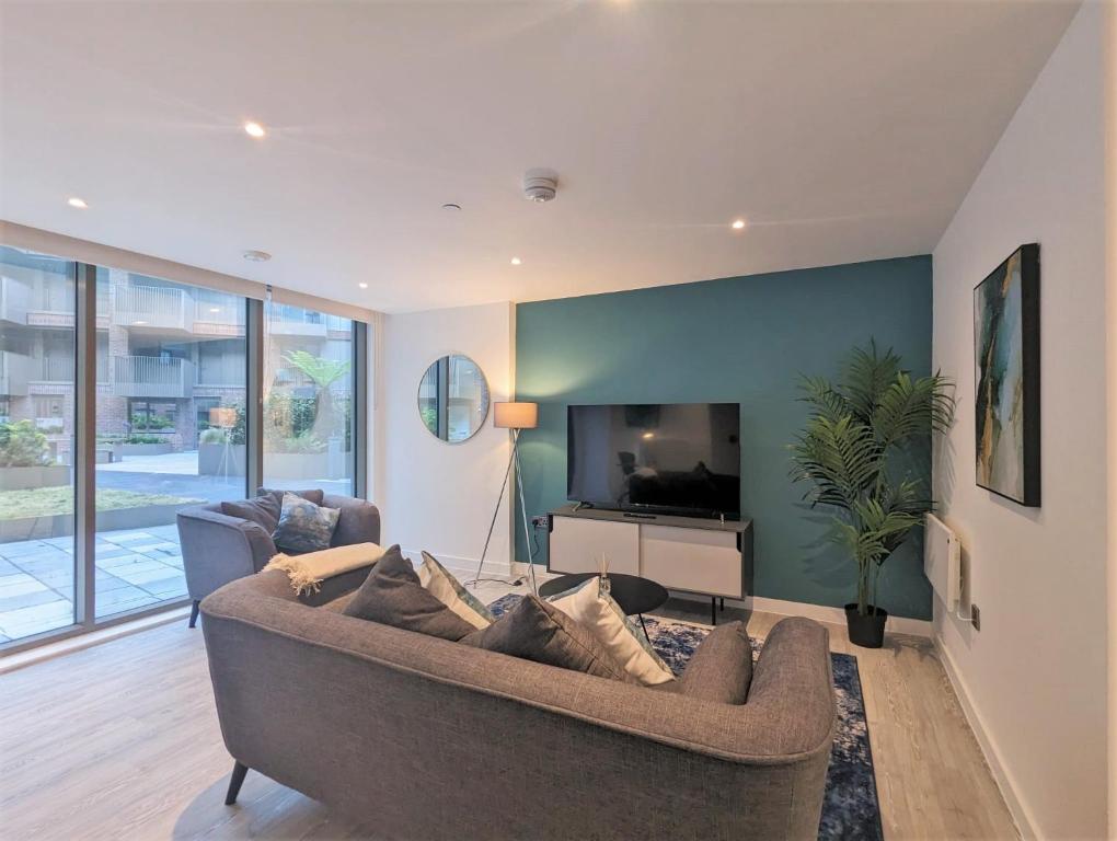 a living room with a couch and a television at Manchester Townhouses by Charles Hope in Manchester