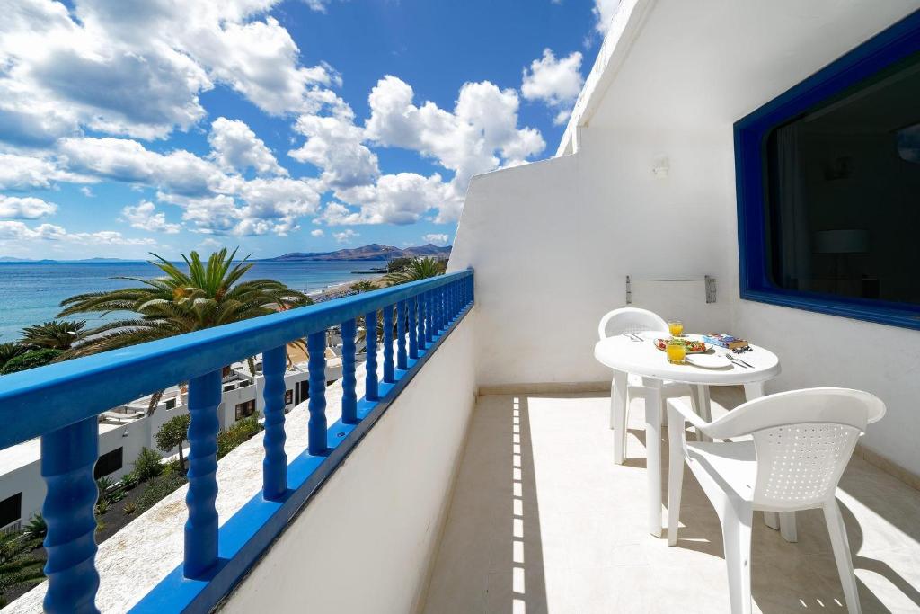 balcón con mesa, sillas y vistas al océano en Labranda Los Cocoteros, en Puerto del Carmen
