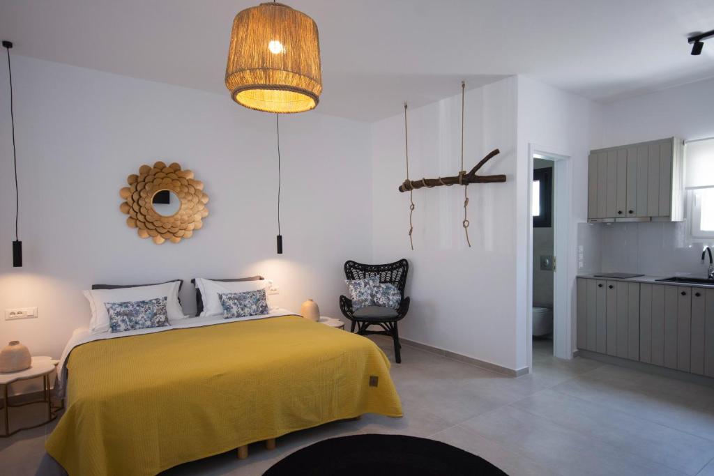 1 dormitorio con 1 cama amarilla y 1 silla en Alko Apartments, en Mykonos ciudad