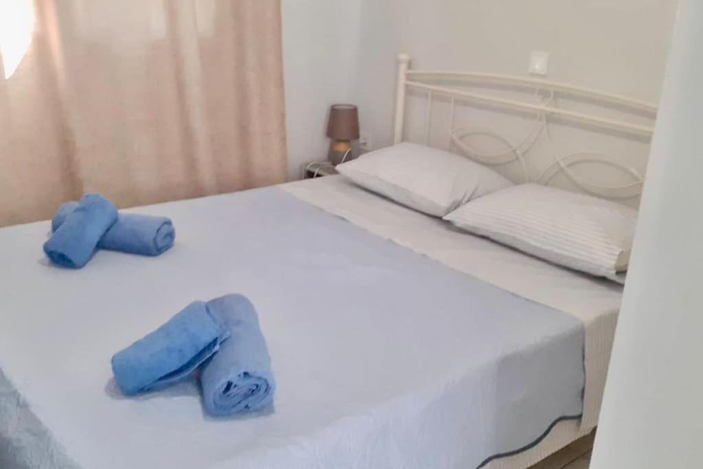 a white bed with two blue towels on it at Handra Apartment Seaview in Kos Town