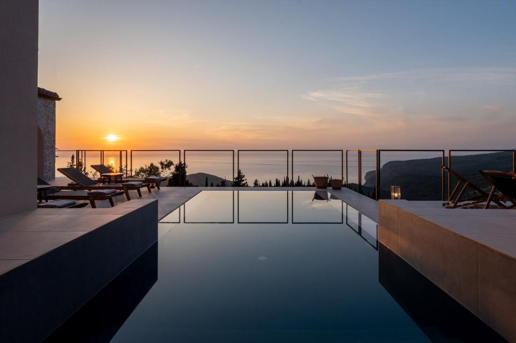 una piscina en la azotea de una casa con puesta de sol en J&C Luxury Villa, en Asos