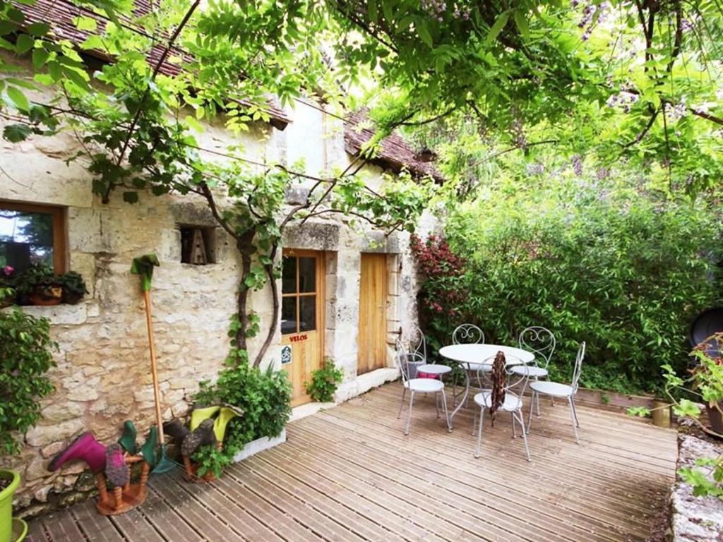 een houten terras voor een huis met een tafel en stoelen bij Gîte Communauté de communes Brenne - Val de Creuse-Pouligny-Saint-Pierre, 4 pièces, 10 personnes - FR-1-591-431 in Le Blanc