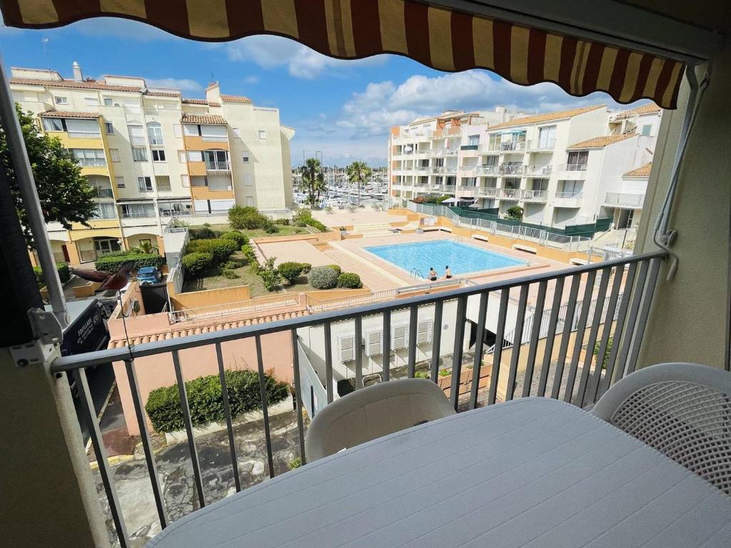 d'un balcon avec vue sur la piscine et les bâtiments. dans l'établissement Appartement Près Plage, Port et Piscine, Parking Privé - FR-1-723-111, au Cap d'Agde