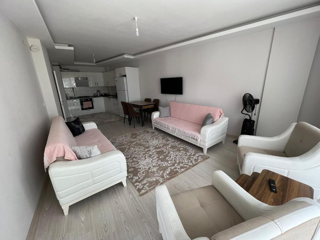 ein Wohnzimmer mit weißen Möbeln und einem rosa Sofa in der Unterkunft Balkonlu Lüks Eşyalı Aile Evi in Sinop
