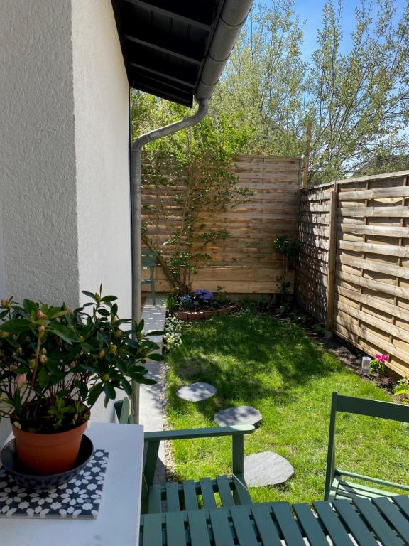 a backyard with a fence and a table and chairs at Maison cosy rénovée avec jardin in Rouen
