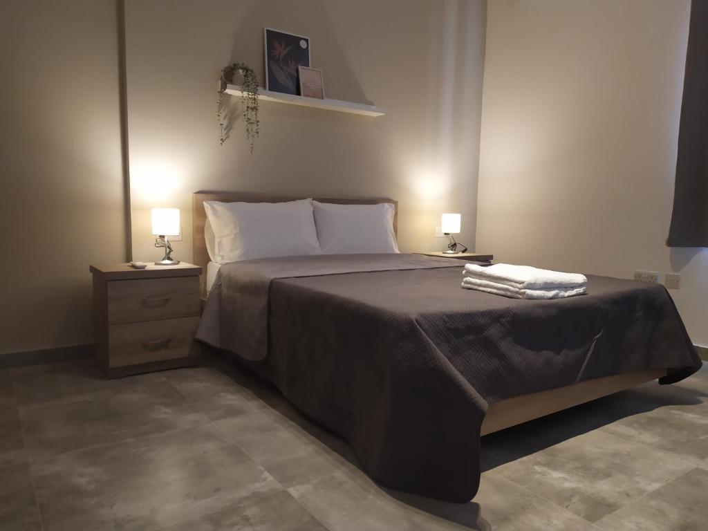 una camera da letto con un grande letto con due comodini di No. 38 Appartments a Sliema
