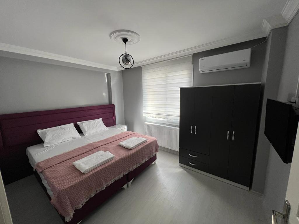 a bedroom with a bed with a dresser and a television at NOKTA SUITE APART in Pelitli