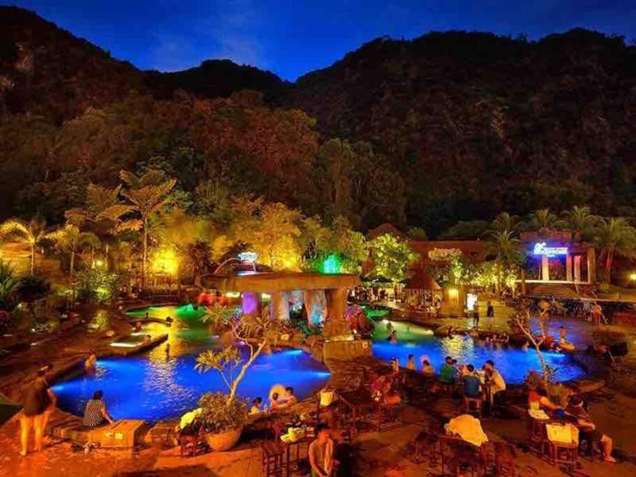 een resort met mensen die 's nachts rond een zwembad zitten bij Stylish Cozy House Near Ipoh Lost World Tambun in Kampong Batu Lapan