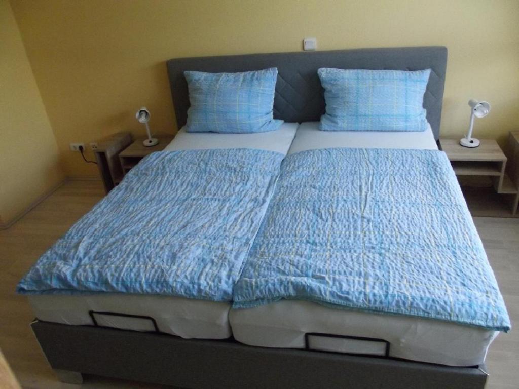 ein Bett mit blauer Bettwäsche und blauen Kissen in einem Schlafzimmer in der Unterkunft Ferienwohnung Reuter Christine in Bad Staffelstein