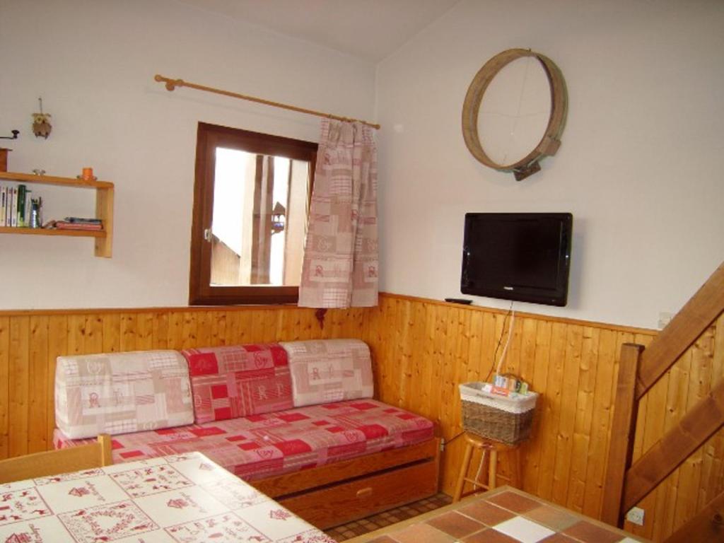 un salon avec un canapé et un miroir dans l'établissement Studio-mezzanine 4 pers, animaux ok, parking, proche pistes et commerces - FR-1-733-114, à Crest-Voland